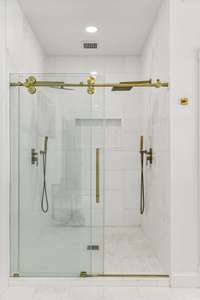 Master shower has his and hers rain shower heads.