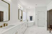 Double vanity has quartz counter tops and two sinks with champagne gold hardware.