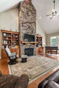 Large living room boast a stunning floor to ceiling stone fireplace.