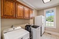 Laundry room has space to store all your cleaning goodies plus a folding counter opposite the appliances.