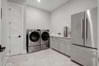 Laundry room, built in cabinets, sink and 2nd fridge