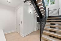 Entry level storage cubbies next to elevator and floating staircase