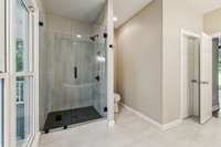 Beautifully tiled shower, potty nook, and large walk in closet behind the closed door.