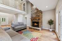 Living Room with charming stacked stone wood burning fireplace.