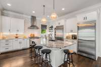 Oversized lighting, under cabinet lighting, separate refrigerator and freezer, and coffee bar area, this kitchen has it all.