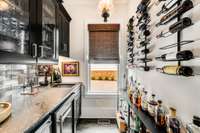 Wet bar equipped with wine fridge, ice maker, bar sink and wine storage