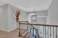 Upstairs landing is airy and open. Striking wainscoting at front and rear staircases.