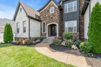 This stunning 6 bedroom, 5/2 bathroom, and 5,767 sq. ft. home features an exquisite exterior w/ Alley Cassetty Nottingham Tudor brick, Valley Forge cobblestone, ivory buff mortar, and Barbury Iron Lion bronze & glass double doors at the front entry.