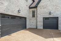 3-car attached garages and aggregate concrete driveway with parking pad.