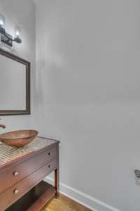 Powder room near the mudroom and butler's pantry makes a perfect pool bathroom. Beautiful multi-colored glass tile vanity and custom sink.