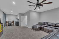 The bonus room also features a wet bar, floating shelves, built-in speakers, recessed lighting and room for a pedestal dining table and seats.