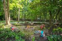 The outdoor living with this home is incredible - Stacked stone firepit next to the Koi Pond