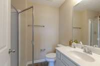 Bathroom in the primary bedroom has a single vanity and a large shower.