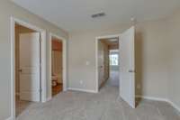 View of the second bedroom looking down the hallway to the primary bedroom