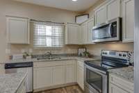 Another view of the kitchen showing a window over the sink for extra lighting.