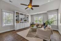 The upstairs living room with ample light is the perfect place to lounge or host friends to watch the big game. Built-ins provide great storage.