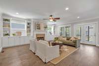 Built-in cabinetry flanking the windows provides ample storage and enhances natural light around the gas fireplace. The living room flows effortlessly into the screened-in porch.