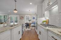 Modern hardware, a farmhouse sink, gas cooktop and great lighting elevate this space.