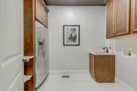 Large laundry room with additional refrigerator and task station.