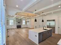 Stone fireplace, waterfall quartz island, and Sub Zero fridge.