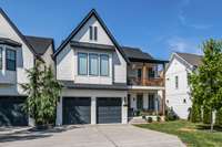 Double front porches and gas lanterns flank the garage.