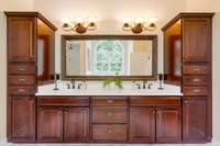 Custom wood cabinets flank the double vanity in the Primary Bathroom