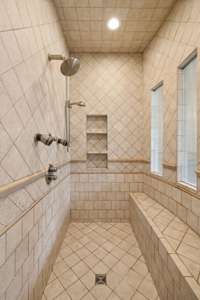 You'll love stepping into this lavish shower completely surrounded with beautiful tile and featuring two shower heads, inlaid niche for sundries plus a long sitting bench.