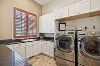 The Laundry Room for Bearden is designed for organization! It can accommodate a large Washer/Dryer set. The Cabinets and Counter Space are extensive. There's also a Sink and nook area for household appliances. The Natural Stone floor is striking!