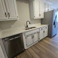 New stainless steel dishwasher and Refrigerator and deep double sink. ]\