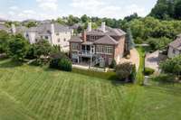 Aerial view of the home, which backs to common ground, then the golf course. Note the impressive size of the driveway that will allow for a multiple guest parking area in addition to the 3 car epoxy surfaced garage.