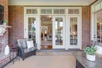 This main level screened porch has a gas fireplace, surround sound speakers, tiled floor and a ceiling fan.