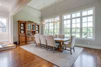 The breakfast room with a built in buffet is washed in sunlight from the wall of windows overlooking the 13th hole of the golf course.