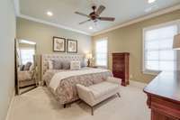 Another large bedroom with beautiful crown molding and ceiling fan.