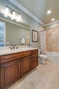 Large, tiled bath with full tub and recessed lighting.  All suites in this home have full bath access.