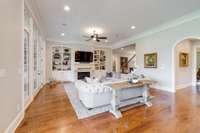 Large great room with gas fireplace flanked with built-in shelving.