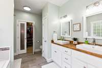 Primary bathroom with tile shower, tub, walk-in closet, and upgraded double vanity