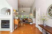 View from front door: hardwood floors, double-sided fireplace, 16 foot ceilings