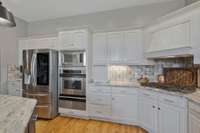 Tile backsplash, gas cooktop, oven and warming drawer..