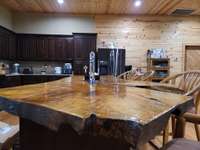 Wood slab cut from a local tree separates the Kitchen from the Living Room area as a beautiful island