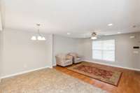 Original photo of Dining and Living Room. New Luxury Blinds on every window throughout the home. Ceiling fan and additional recessed lighting in living room.