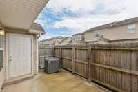 Private Patio with Storage Closet, outdoor lighting, and Privacy Fence with gate to the green space.