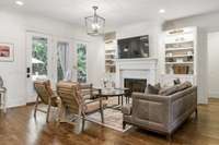 Living room offers built-ins (with lighted shelving and cabinet storage) surrounding fireplace and walks out to the private backyard oasis.