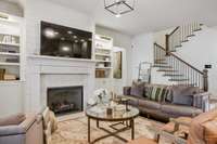 Living room offers built-ins (with lighted shelving and cabinet storage) surrounding fireplace and walks out to the private backyard oasis.