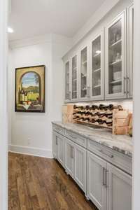 Transitioning between the kitchen and formal dining room, the butler pantry features a built-in buffet with glass fronted upper cabinets.