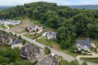 Home sits nestled on a hillside surrounded by a beautifully landscaped yard and wooded backyard.