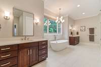 Double vanities on either side of window, Soaking tub under window, Oversized rainfall shower with triple shower heads and floor-to-ceiling tile, Linen closet and water closet