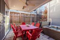 Just steps down from the kitchen and dining area is an outdoor dining terrace and hot tub area with privacy from the neighbors