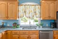 The kitchen sink is under a window that looks out into the back yard.