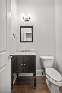 The Main Level Powder Room offers a marble top furniture style vanity and framed mirror.