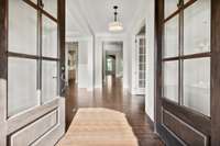 Step through the arched double 6-light wood doors into this inviting Foyer. Hardwood flooring and unique drum light fixture leave a lasting first impression while hardwood treads and metal railings on the staircase finish the space.